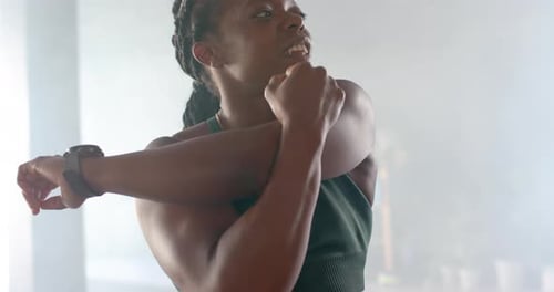 Stretching arms, strong fit woman in gym wearing fitness attire, preparing for workout