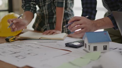 Architects Working on Construction Blueprint at Wooden Desk