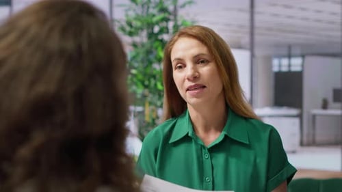 Woman in Green Shirt Speaking in Modern Office