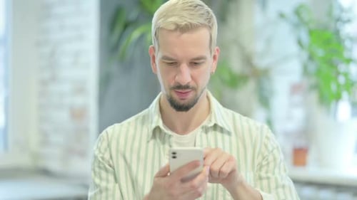 Man Using Smartphone in Modern Interior