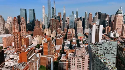 Bright sun lighting the facades of multistoried buildings and skyscrapers of New York.