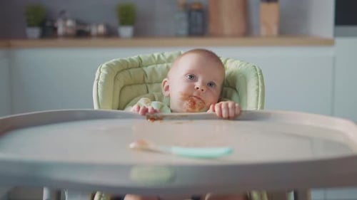 Close Up Funny Young Baby in Feeding High Chair After Eating Happy Child with a Foodstained Face