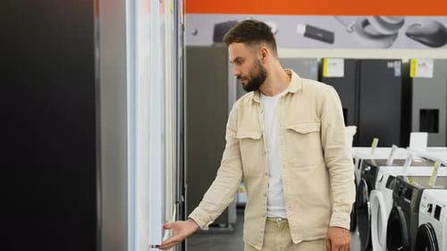 Customer Examining Refrigerator in Electronics Store