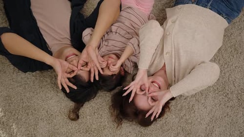 Playful Family Lying on Carpet Making Funny Faces