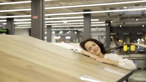 A Brunette Woman Chooses a Laminate in a Hardware Store Shopping for Home Repairs