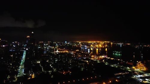 Nighttime aerial view of a vibrant cityscape with illuminated streets and buildings