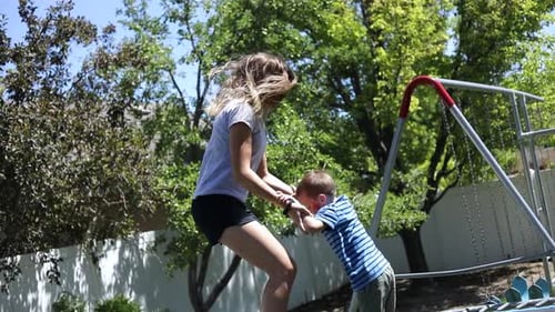 Woman and Child Playing on Backyard Trampoline