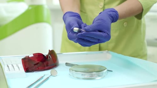 Dentist hands inserting drill in dental turbine at modern teeth care clinic