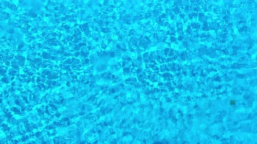 Blue Water in the Swimming Pool with Light Reflections