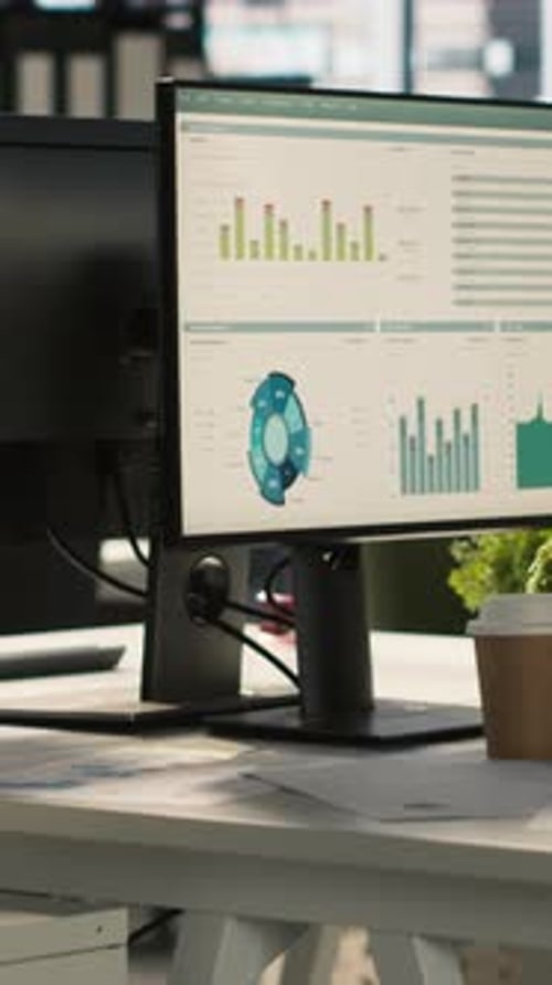 Vertical Video Modern Office Workspace Desk with Computer Monitors Displaying Graphs