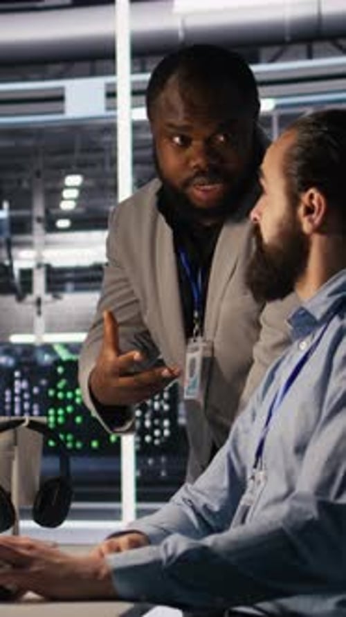 Men Analyzing Data in a Dark Server Room