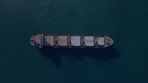 Topdown Aerial Drone View of a Large Cargo Ship Sailing on Open Water Showing Industrial Details and