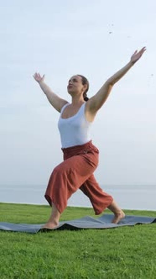 Asana de yoga matinal sur la côte de la mer par une femme