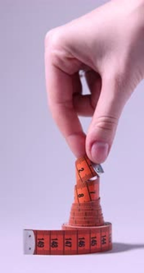 Measuring Tape Being Pulled Upright by Hand