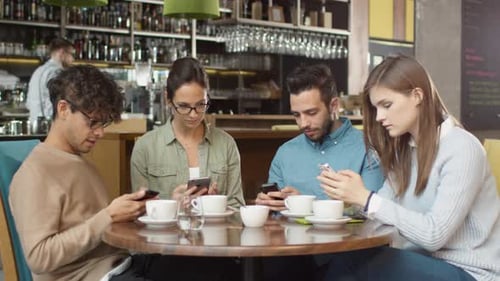 Group of Young Mixed race People using Phones in Coffee Shop.