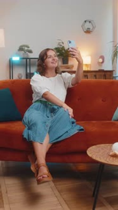 Woman Video Calling on Phone While Sitting on Sofa