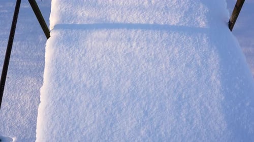POV walking across snow covered metal bridge, downwards view on shoes