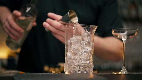 Bartender Pouring Drink into Ice-Filled Glass