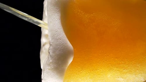 Beer Overflowing with Foam in Slow Motion
