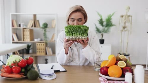 Nutritionist Doctor Holding Healthy Greens in Sunny Office