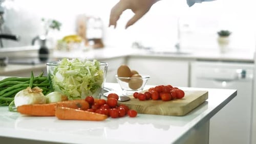 Nahaufnahme eines Mannes, der Gemüse schneidet, um allein zu Hause gesunde Salate zuzubereiten. Konzept der gesunden Ernährung