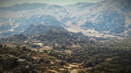 A Majestic Mountain Range Surrounded By Lush Trees and Rugged Rocks