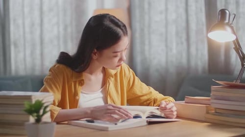 Diligent Woman Studying at Home Desk with Books