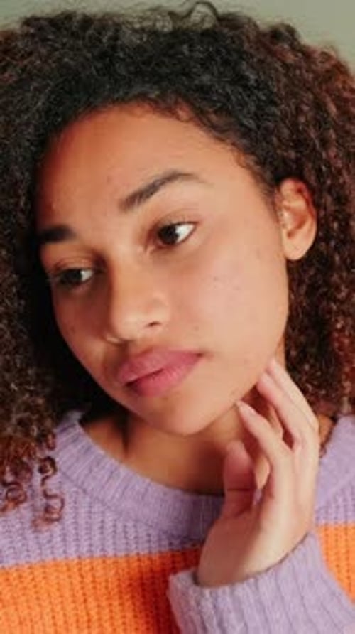 Smiling Woman Poses with Curly Hair and Sweater