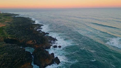 Aerial View of Waves Crashing on Rocky Coastline