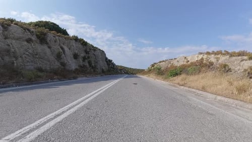 Scenic Coastal Road View From a Moving Car with Sea in the Distance Rocky Cliffs on One Side and Dry