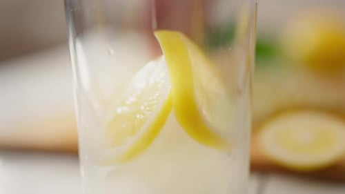 Fresh. A young parent carefully adds mint to a drink in the kitchen of a private home. General view