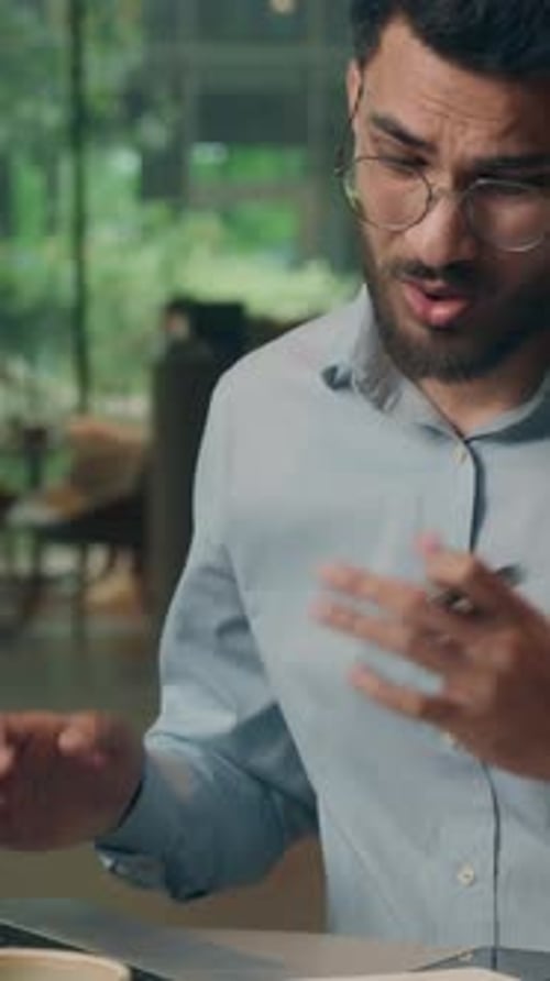 Stressed Young Adult Male with Headache at Work