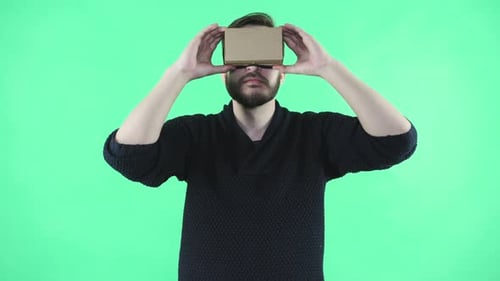 Man Using Virtual Reality Headset Against Green Background