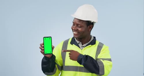 Happy black man, engineer and phone green screen in marketing against a studio background