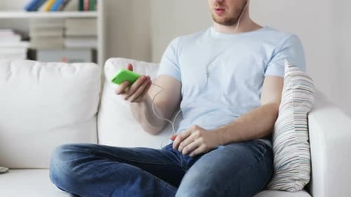 Man Relaxing on Sofa Using Mobile Phone