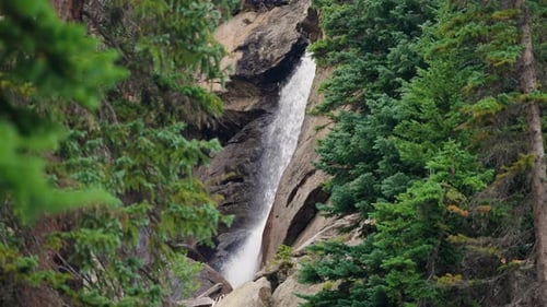 Dreamy Waterfall Flowing Through A Quiet Forest Filled With Soft Light