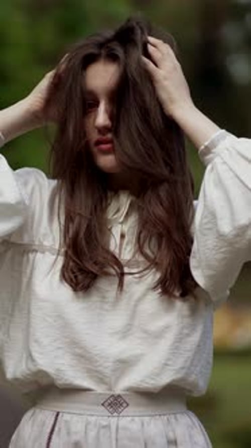 Beautiful Fashionable Model Smiles Posing Outdoors and Straightens Her Long Hair Charming Brunette