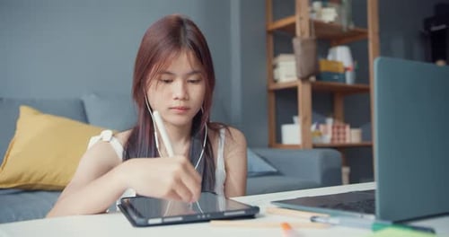 Young Woman Using Stylus and Tablet at Desk