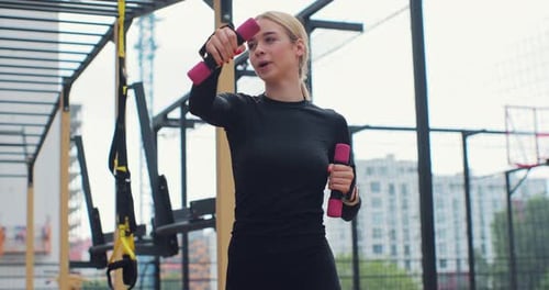 Woman Doing Strength Exercises with Weights Outdoors