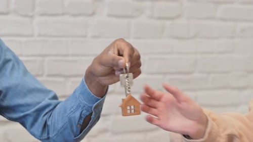 Close up of African Real Estate Agent Giving Home Keys to Woman