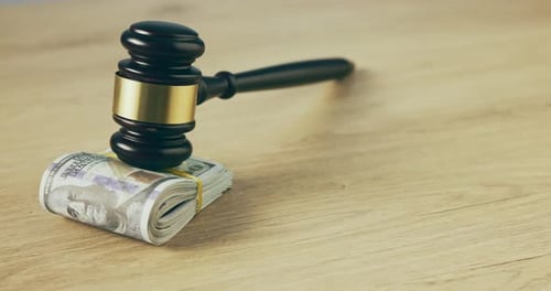 Geld, Richterhammer und Barbestechung auf einem Tisch für Versteigerung, Korruption und Gerichtskosten
