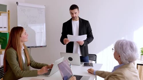 Young Businessman Having a Presentation to Company Coworkers at Meeting Room