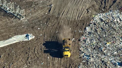 View From Above of Landfill Dump Site for Garbage Waste Management Bulldozer Tractors Burying Large