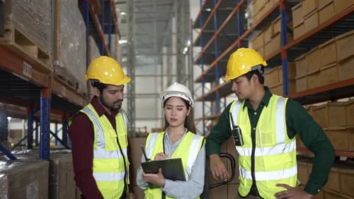 Blue collar workers are working at warehouse.
