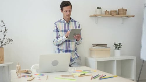 Using Tablet While Standing in Office Browsing Internet