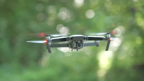 Drone Copter with Blurred Propellers and Video Camera Flying in Air