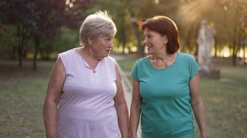 Two Happy Elderly Women Walk and Talk