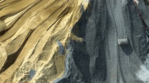 Aerial view of a bustling cement mixing plant with silos.