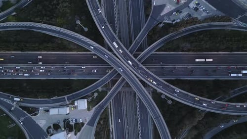 Top Down Zoom Out Aerial View of Highway Interchange with Traffic and Overpass Bridges at Evening