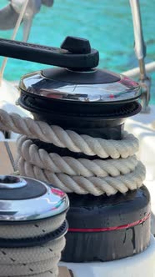 Closeup of Hands Tightening Rope on Winch During Sail Hoisting on Sailing Yacht Teamwork and Manual